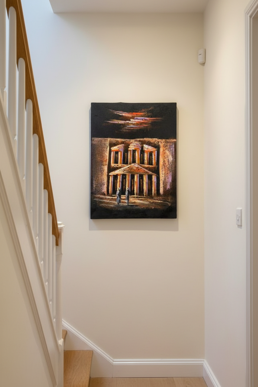 Petra's Treasury at Night oil painting on cream white wall in intimate hallway near staircase — no frame, lifestyle interior staging
